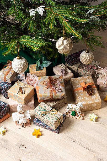 A cozy Christmas scene with elegant natural-toned gift boxes placed under a Christmas tree, lit with festive lights, evoking peace and seasonal joy