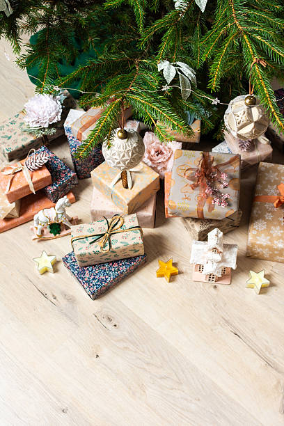 istock A cozy Christmas scene with elegant natural-toned gift boxes placed under a Christmas tree, lit with festive lights, evoking peace and seasonal joy 2221049338