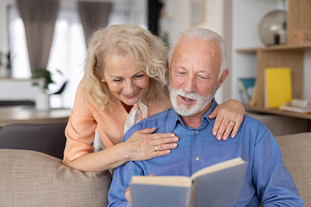 istock Elderly couple sharing smiles while reading together 2221050732