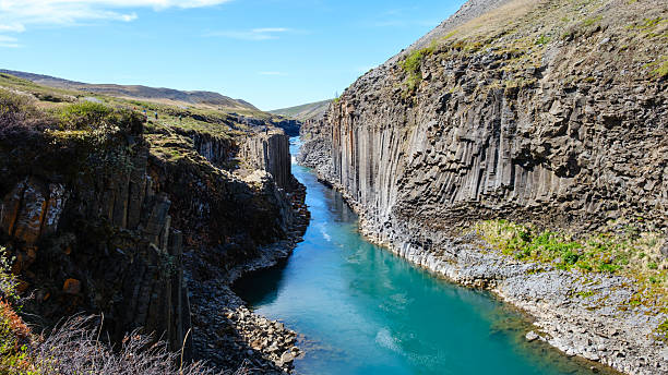 istock Explore the stunning beauty of Studlagil Canyon with its unique basalt columns and tranquil waters 2221051773