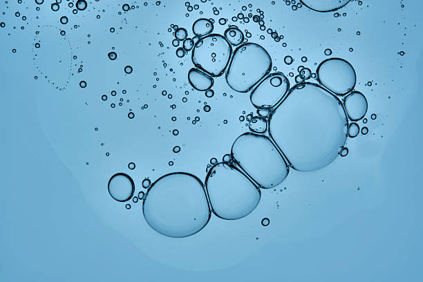 istock A beautiful drop of cosmetic product with bubbles on a blue background. 2221053722