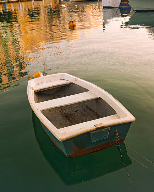 istock Wooden Rowboat Moored in Shallow Water with Sunlight Reflection 2221054689