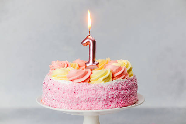 1 Year Birthday Concept. Abstract Birthday Cartoon Dessert Cherry Cake with One Year Anniversary Candle on a white background. 3d Rendering
