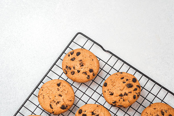 istock Freshly baked chocolate chip cookies cooling on a wire rack indoors 2221055167