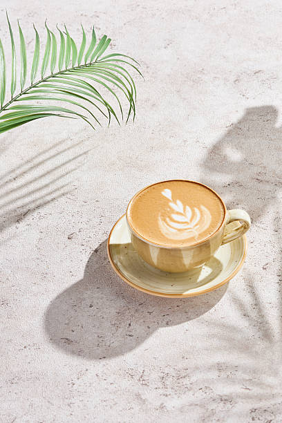 istock Cappuccino with leaf latte art, bright natural lighting, minimal overhead composition 2221055334