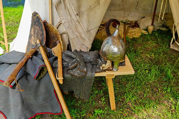 istock Medieval Armor and Weapons Display Outdoors. Reenactment Gear with Axe and Helmets. Viking Style Equipment at Medieval Fair. 2221056524