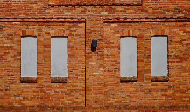istock Red brick wall. Windows are sealed and plastered. Space for text. 2221057321