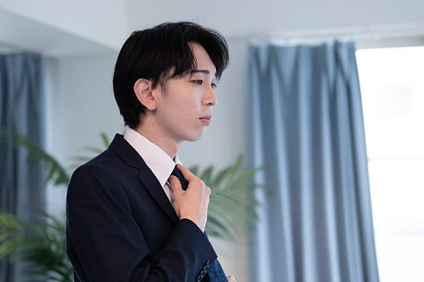 A Japanese man in a suit getting ready in the morning