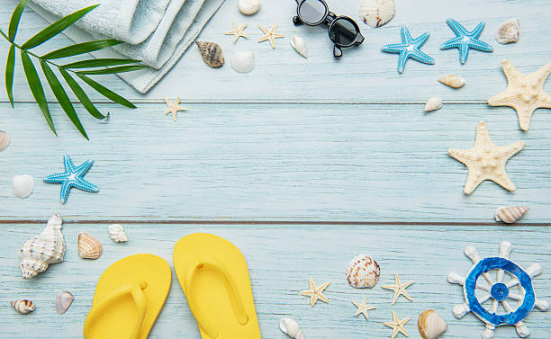 istock Summer essentials creating a frame on a light blue wooden background, ideal for travel and vacation themes 2221059056