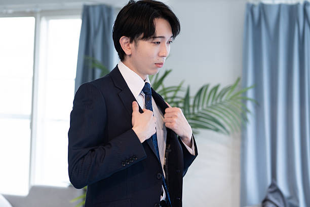 istock A young Japanese man adjusting both lapels of his suit jacket 2221059135