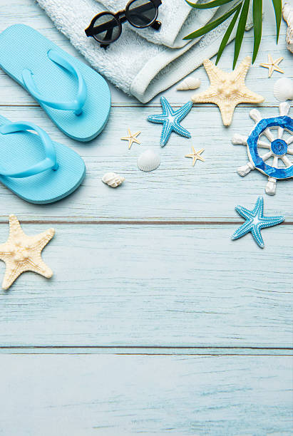 istock Summer accessories creating a frame on light blue wooden background 2221060193