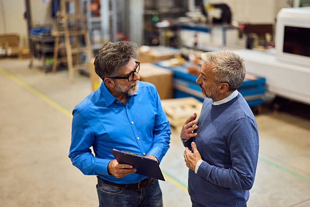 istock Two Mature Men Engaged in a Discussion at an Industrial Workspace 2221061288