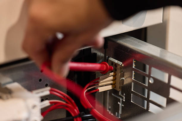 istock Technician Inspecting Wiring Connections in Electrical Device with Multimeter 2221061315
