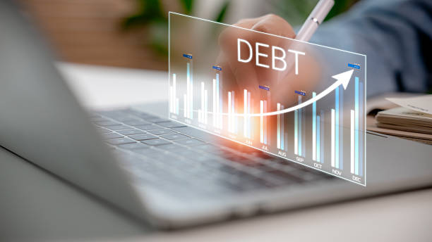 The rising debt graph on the laptop screen represents the increasing financial burden or business liabilities. Concept of debt management, economic crisis, and financial analytics.