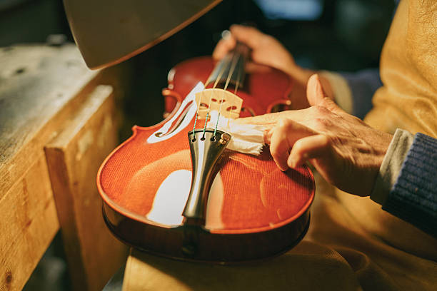 Luthier polishing a violin in a well-lit workshop, using a cloth and focusing on intricate details, embodying the passion and skill of handcrafted instrument restoration