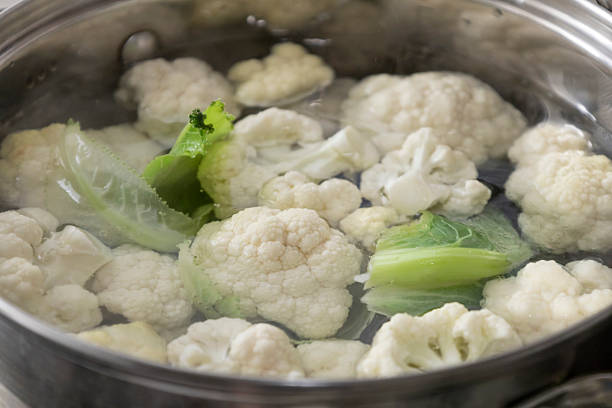 istock Fresh cauliflower is boiled in a saucepan with water. The vegetable is divided into florets and boiled in a saucepan. 2221064655