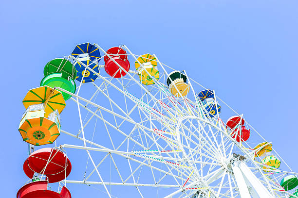 istock Colorful ferris wheel against a clear blue sky, showcasing vibrant gondolas and structure 2221066443