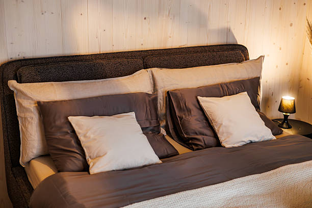 istock Cozy Bed with Neutral Pillows and Warm Ambient Lighting 2221069877