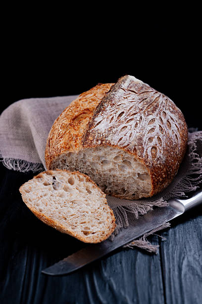 Sourdough Bread Loaf And Slice With Knife On Rustic Wooden Table