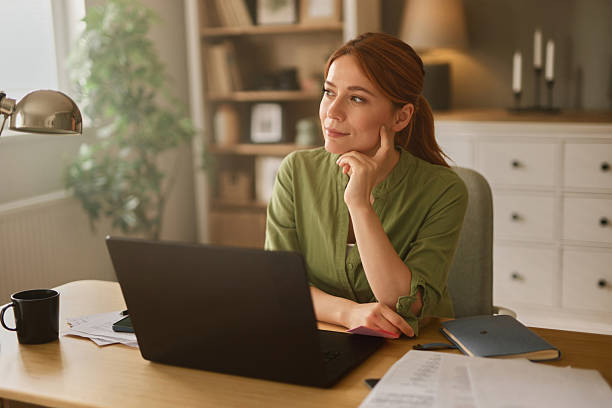 istock Young woman thinking and working from home office 2221071778