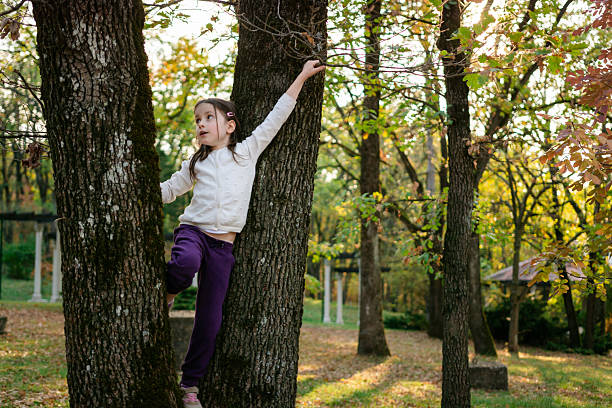 cheerful girl sitting on blossom cherry tree by springtime evening