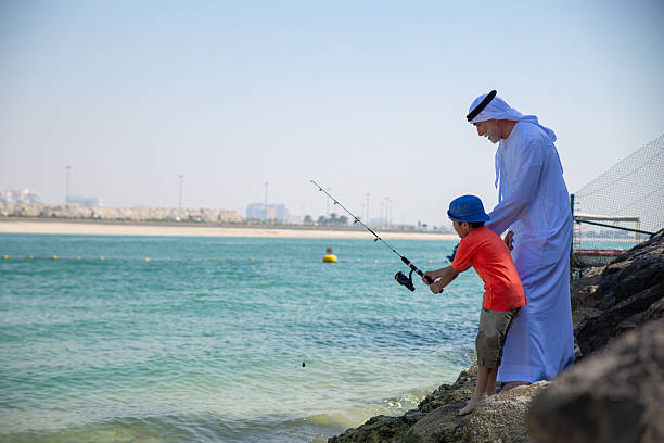istock Arab grandfather and little boy having fun at beach 2221073440