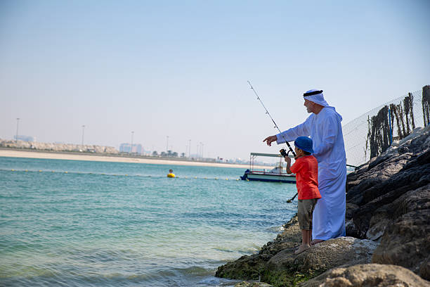 istock Arab grandfather and little boy having fun at beach 2221073448