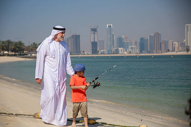 istock Arab grandfather and little boy having fun at beach 2221074027