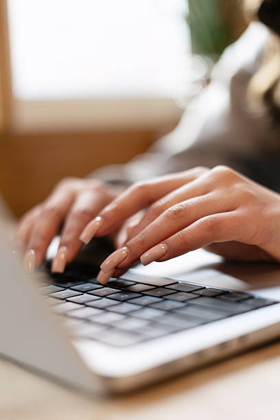 istock Woman typing on laptop keyboard with long nails 2221076410
