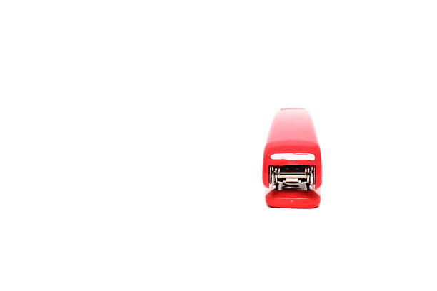 Close-up front view of a red stapler isolated on a white background, an essential office tool