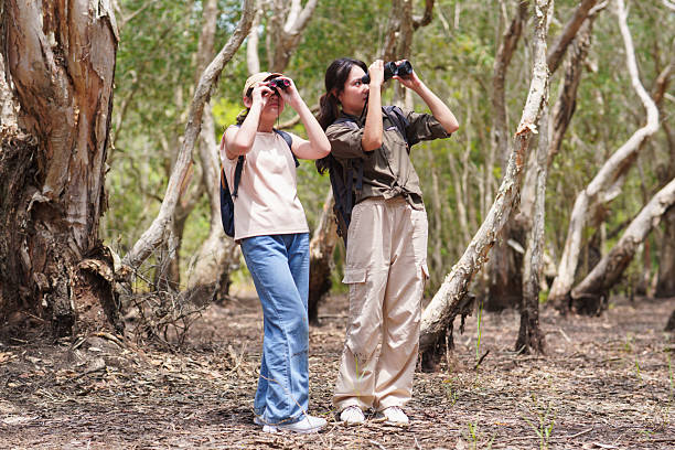 istock Two Asian sisters explore a peat swamp ecosystem with binoculars on a weekend getaway. 2221077588