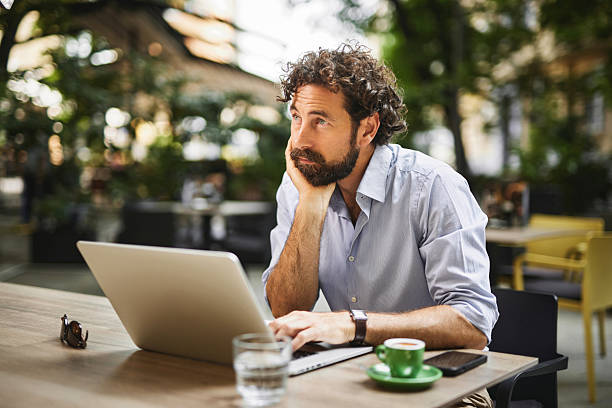 istock Thoughtful entrepreneur working remotely at outdoor cafe 2221077920