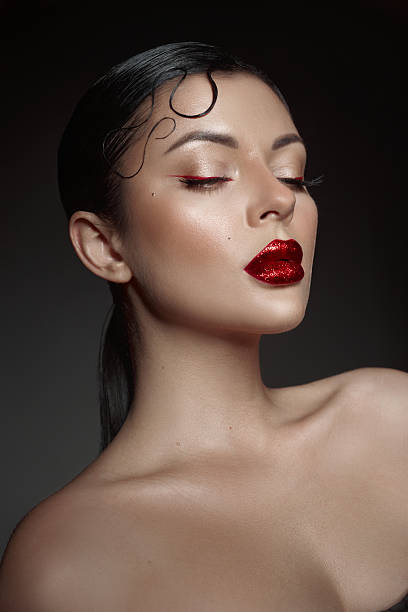 confident model poses with striking red lipstick and expertly applied makeup.