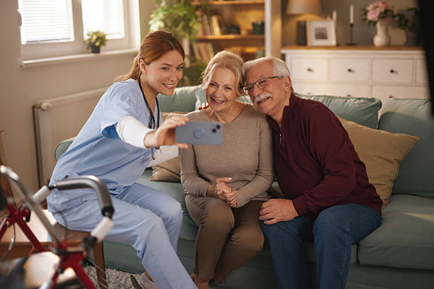 istock Home nurse taking selfie with elderly couple on sofa 2221080027