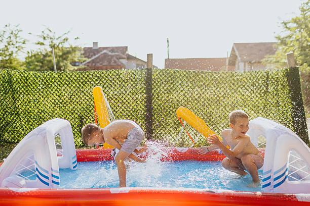 istock Brothers having fun in rubber paddling pool 2221081050