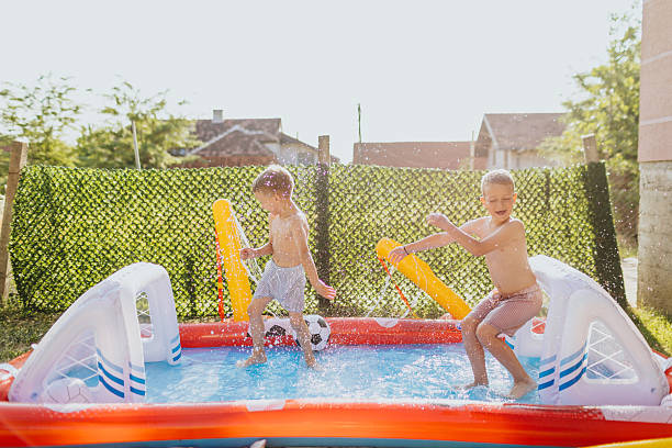 istock Brothers having fun in rubber paddling pool 2221081351