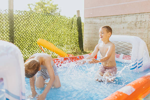 istock Brothers having fun in rubber paddling pool 2221082683