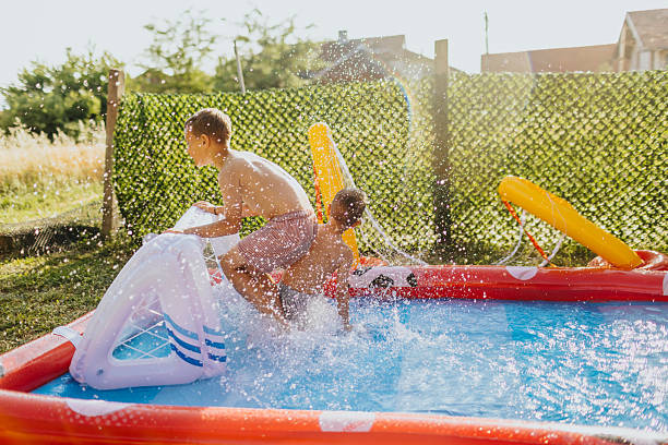istock Brothers having fun in rubber paddling pool 2221082776