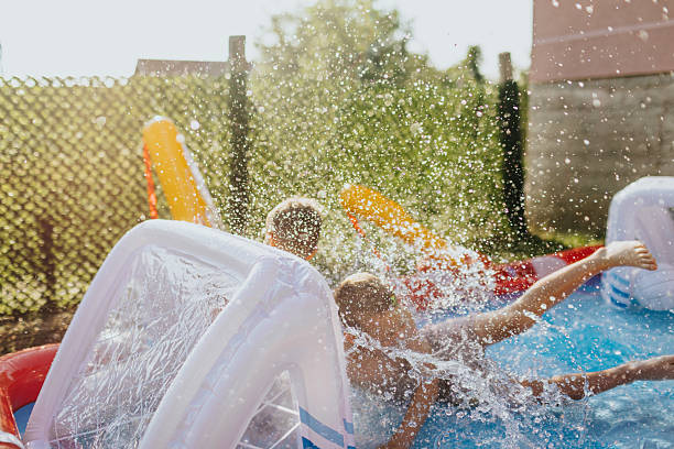 istock Brothers having fun in rubber paddling pool 2221082947
