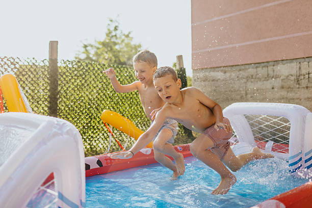 istock Kids playing in home swimming pool 2221083095
