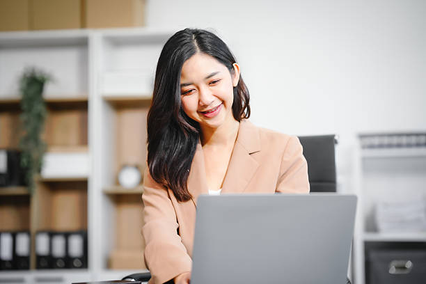 istock An Asian businesswoman works at her desk office, smiling while analyzing financial data planning business strategies on her laptop to enhance profitability,optimize resources,ensure financial growth 2221083287