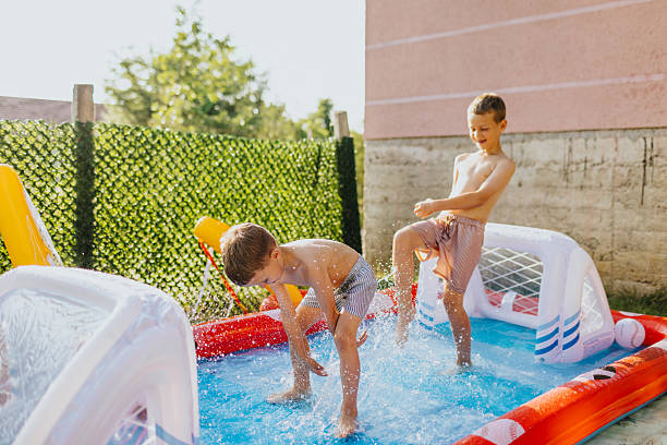 istock Brothers having fun in rubber paddling pool 2221083637
