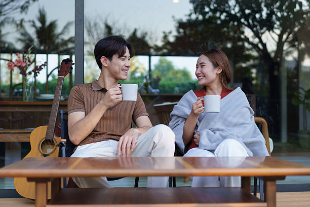 istock A young man covers his girlfriend with a blanket and drinks coffee on their front porch on a winter weekend. 2221084007