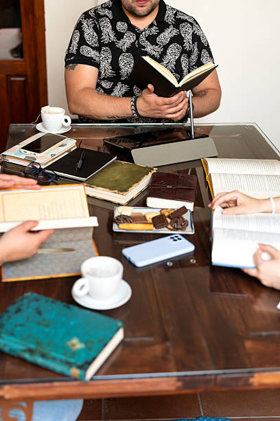 Writers reading and sharing ideas at table with books and coffee