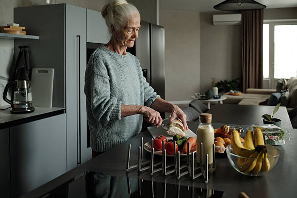 istock Elderly Woman Preparing Healthy Breakfast in Modern Kitchen 2221085851
