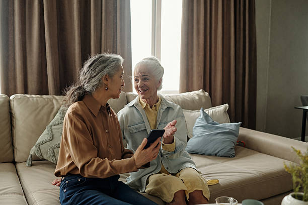 istock Smiling Seniors Chatting and Sharing Stories on Sofa 2221086765