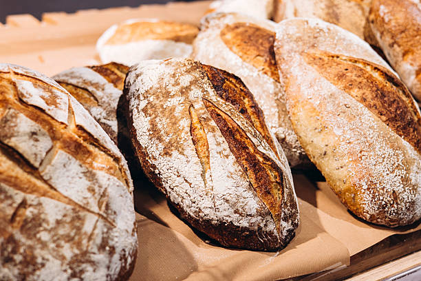 istock Freshly baked bread loaves displayed in bakery window with golden crusts. 2221094105