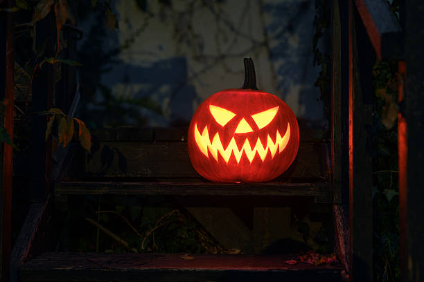 istock Carved pumpkin with inner glow stands outdoor 2221096133