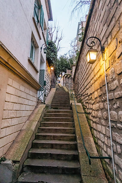 Narrow Stone Staircase Climbing Between Buildings with Glowing Lampposts