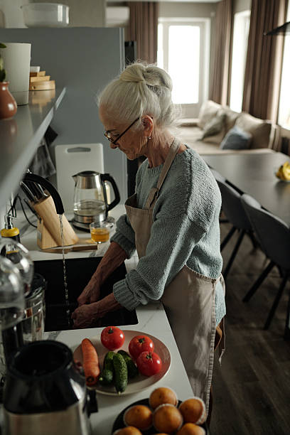 istock Elderly Woman Preparing Vegetables in Modern Kitchen 2221099923